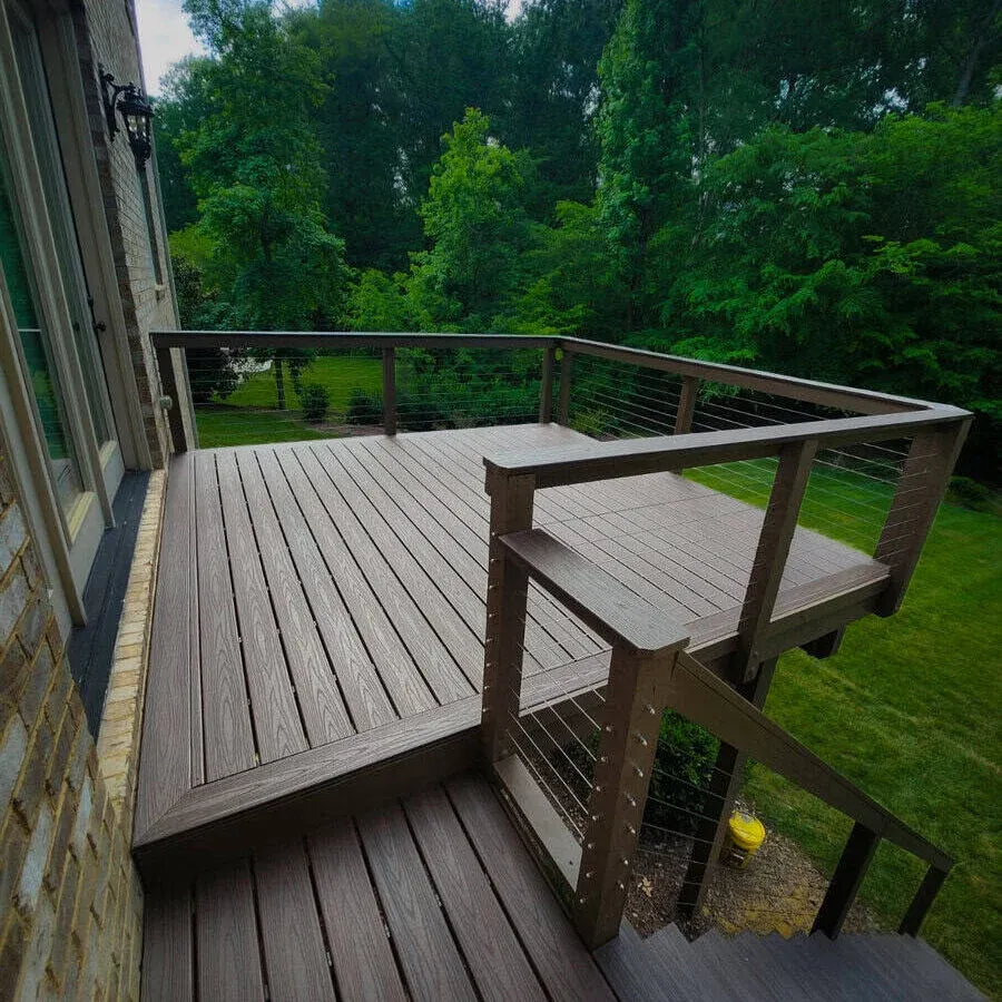 Deck cercado por árvores com guarda-corpo de madeira