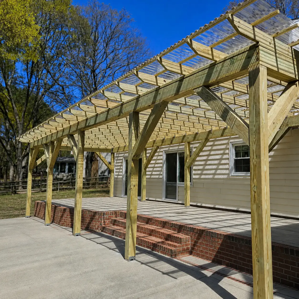 Brazawood custom pergola with a clear roof over a brick patio
